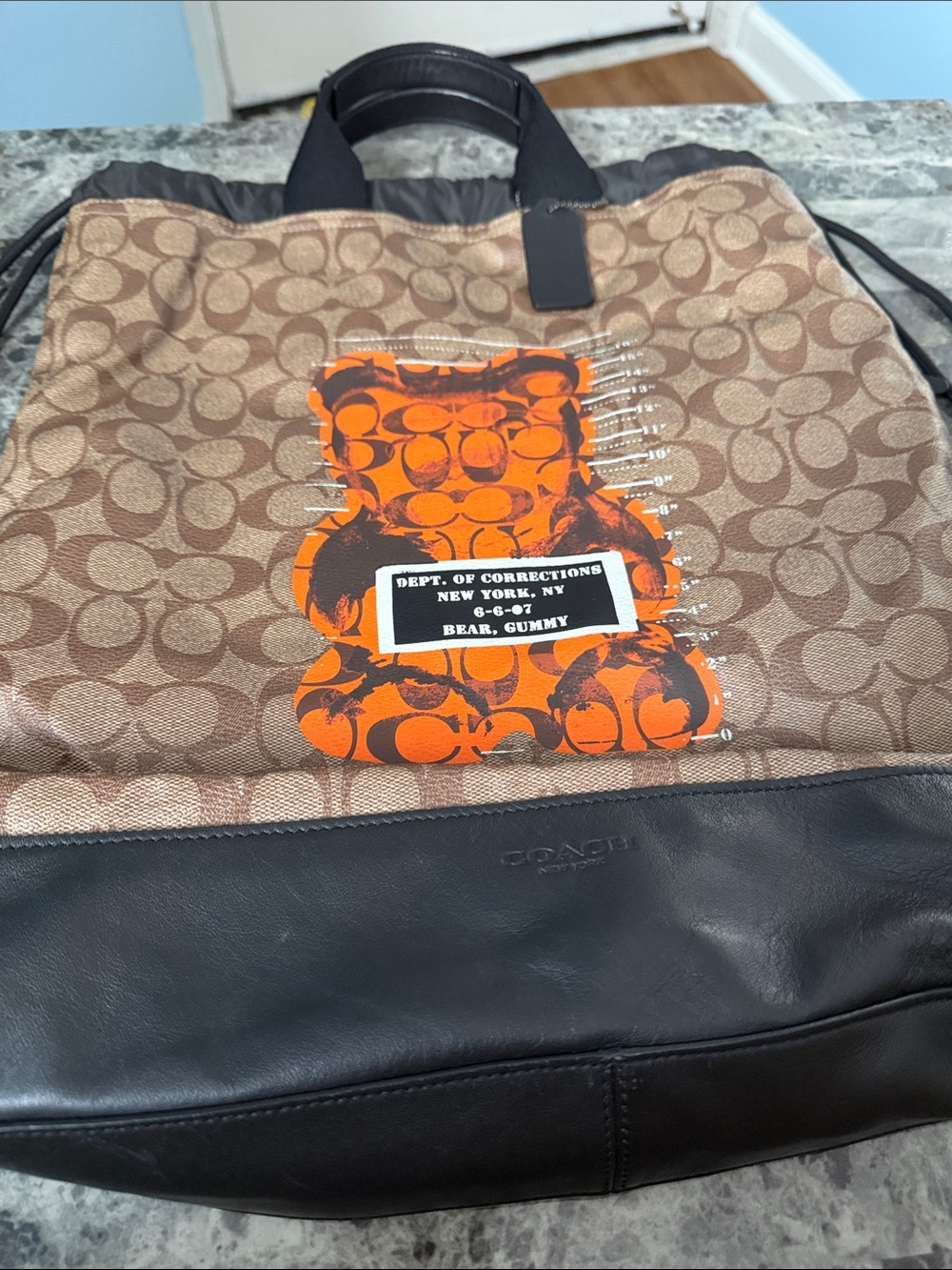 Coach Men’s Brown Signature Drawstring Backpack with Orange Gummy Graphic